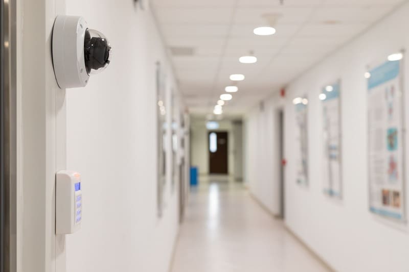 kamera-monitoringu-w-korytarzu-budynku Kamera kopułkowa zamontowana w korytarzu budynku z systemem kontroli dostępu